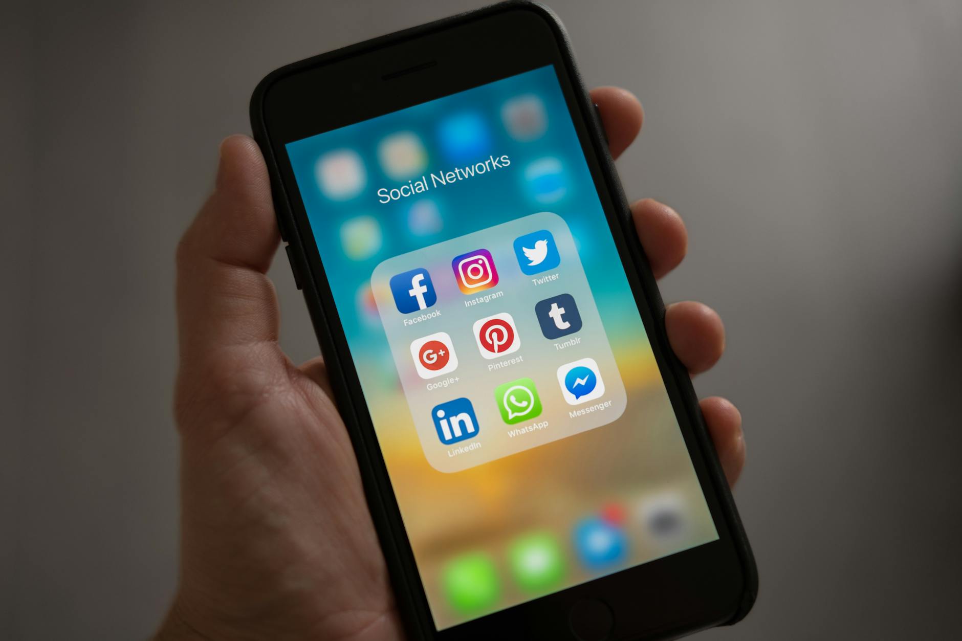 Un smartphone avec les icones des réseaux sociaux illustrant l'importance que les entreprises intègrent le community management dans leur communication